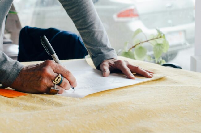 Designer leaning over table
