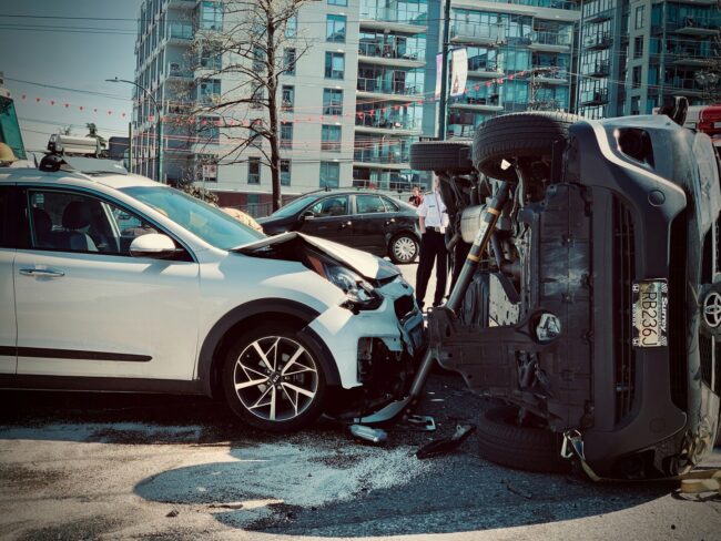 Rollover car crash automobile traffic accident broadside collision causing rollover with first responder firemen stabilization brace deployed.